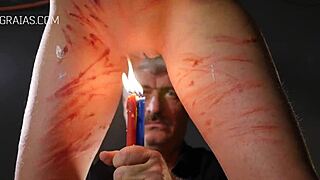 Redhead gets punished in the garage with lit candles