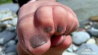 goddess in tan nylons shows her cute nylon soles and toes on the riverside