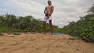 African guy gets handjob and cums on the beach