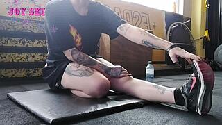 this alternative girl with tattoos stretches at the gym
