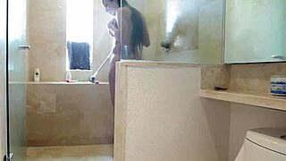 Glamorous tattooed Latina relaxes in the shower wearing a bikini