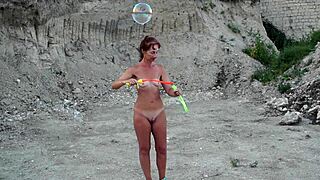 Soap bubbles outdoor with naked mature wife