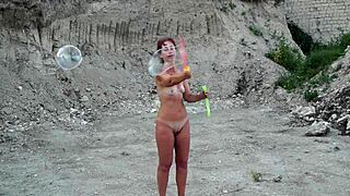 Soap bubbles outdoor with naked mature wife