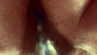 She masturbates her hairy pussy with a glass dildo up close