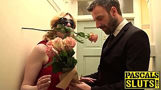 Busty British woman holds rose in mouth during sensual encounter.