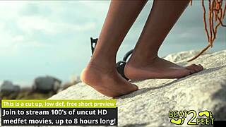 giggles rubs bare feet all over giant hot beach rock closeup