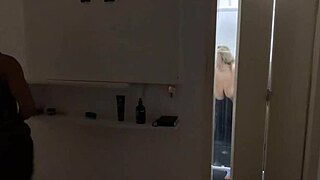 Blonde showers and changes clothes unaware until spotting the hidden watcher—what unfolds?