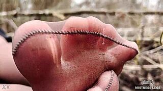 goddess teases feet in tan pantyhose through spring forest leaves