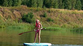 Skinny tall babe flashes pink micro bikini outdoors at beach garden