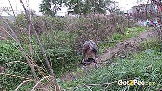 pretty brunette squats low to pee publicly in lush outdoor nature spot