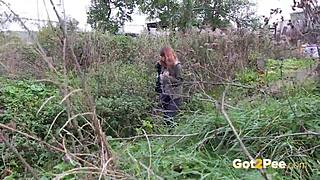 pretty brunette squats low to pee publicly in lush outdoor nature spot